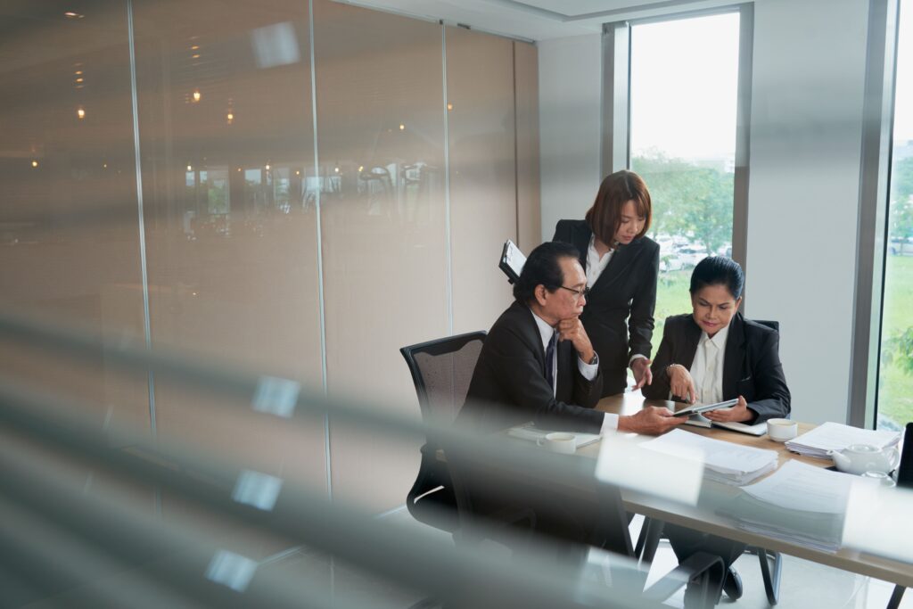 vietnamese-business-team-discussing-document-tablet-computer-min