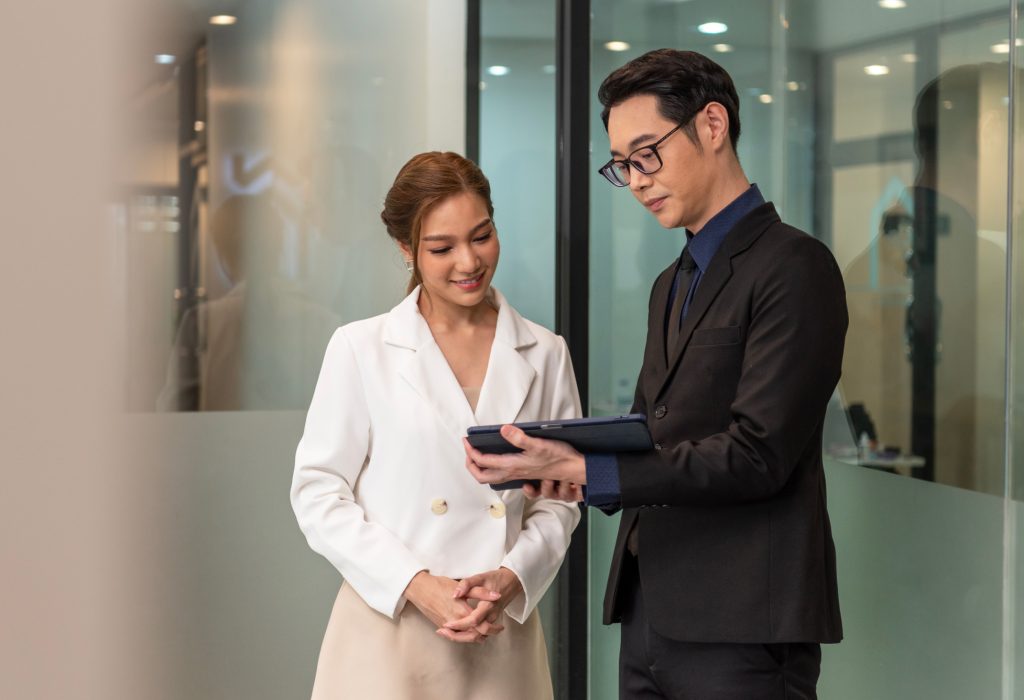 smiling-asian-businesswoman-showing-document-report-her-manager-during-meeting-office 1